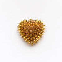 A dime-size (3/4") gold resin heart pendant that has 70+ gold metal spikes covering the entire surface.