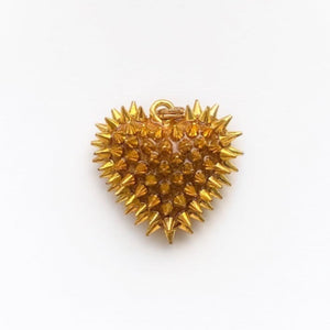 A dime-size (3/4") gold resin heart pendant that has 70+ gold metal spikes covering the entire surface.